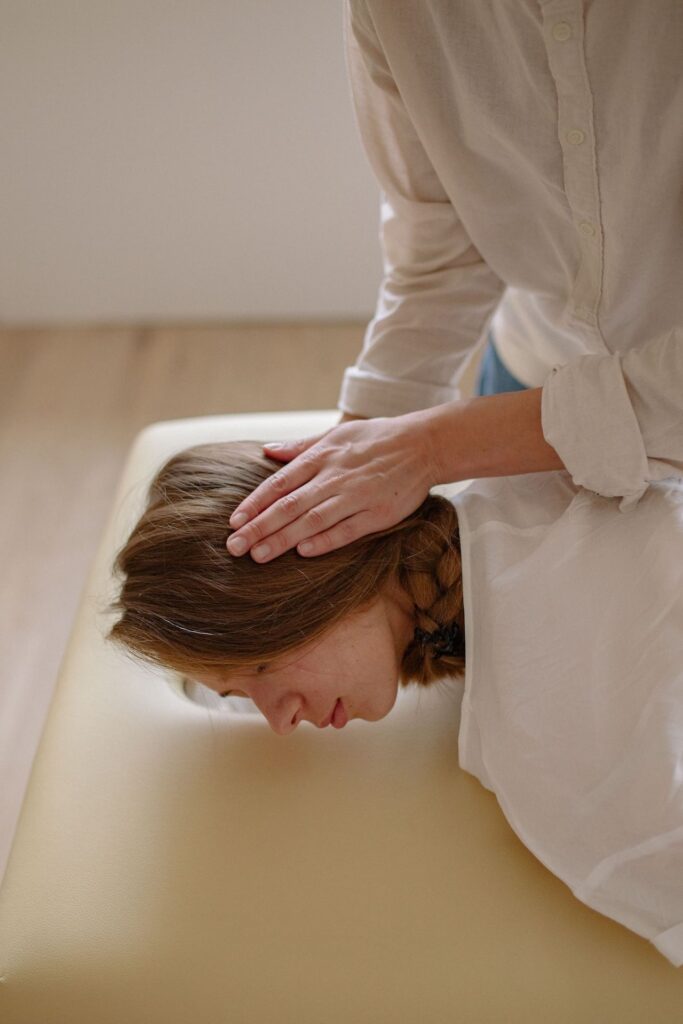Osteopaat behandelt het hoofd van een cliënt tijdens een osteopathische behandeling